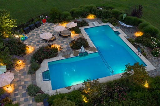 aerial view of bright blue pool surrounded by plants