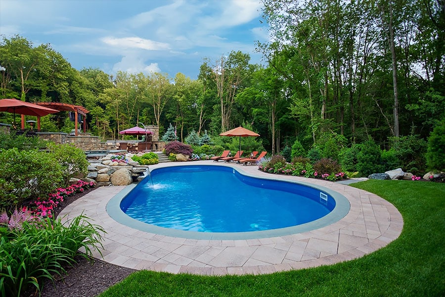A serene pool nestled within a breathtaking landscape designed by our pool landscaping and lighting services in NY, NJ and CT A serene pool nestled within a breathtaking landscape designed by our pool landscaping and lighting services in NY, NJ and CT